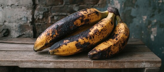 Aufkleber - Ripe bananas start to decay and their skin turns black The bananas are set on a wooden bench Close up photo. with copy space image. Place for adding text or design