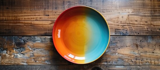 Leinwandbilder - Top view of a vacant colorful plate on a wooden surface Blank space for your design. with copy space image. Place for adding text or design