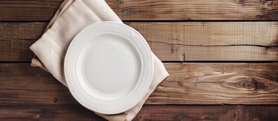 Fototapete - Empty white plate on a light napkin against a wooden background Top view. with copy space image. Place for adding text or design
