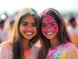 © Nurul - Two girls smiling, covered in vibrant colors, celebrating the joyous festival of Holi.