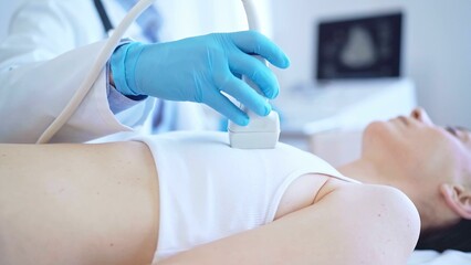 Wall Mural - Doctor man, wearing blue medical gloves, is using ultrasound machine to examine internal organs of a patient woman, close up vie. Female mammary gland health. Medicine