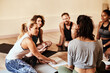 © peopleimages.com - Studio, group and people with listening for yoga, mindfulness and holistic progress with feedback. Class, women and man as friends with notebook, healing information or support for mental health tips