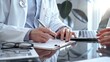 © volha_r - Doctor man is writing something while consulting patient on the glass desk and a clipboard in medical office. Medicine concept