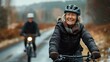 © ifoto - Photograph of an older couple on the road, wearing helmets and smiling while riding their bicycles in nature