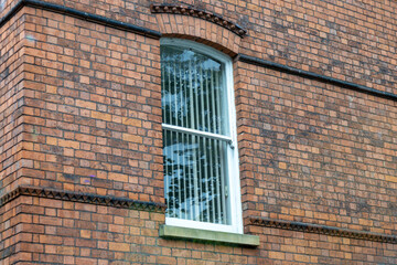 Full frame texture background of a red brick European building with a single arched window