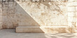 © Moses - Minimalist Yucatan architecture featuring whitewashed stone walls with dramatic natural sunlight casting geometric shadows. Stone bench against textured wall creates clean lines and peaceful com
