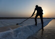 © Scopio - Man sweeping salt during golden hour