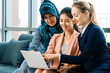 © InfiniteFlow - Multicultural working group. Team of businesswomen of different ethnicity, Caucasian, Asian and Arabic working together with laptop computer at office workplace. Multiethnic teamwork concept. uds