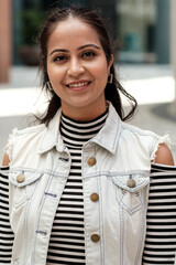 Young indian woman smiling outdoors in urban setting