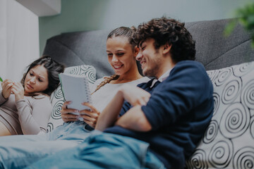 Poster - A group of smiling students sit together on a cozy couch, discussing notes and studying with notebooks. They are relaxed, engaged, and enjoying their learning session.