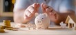 © serdon - An entrepreneur is in a position to take care of the piggy bank and paper family in hand, which includes donation, saving, charity, a family finance plan, fundraising, superannuation, and a financial