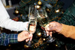 © Seventyfour - Hands of people clinking glasses with champagne celebrating Christmas together at home party, copy space