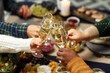 © Seventyfour - Cropped shot of people raising toast clinking glasses with champagne while celebrating Christmas together at home dinner, copy space