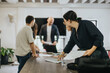 © qunica.com - A group of students working together on projects, receiving guidance from their professor. The setting reflects teamwork, learning, and support, emphasizing a collaborative educational environment.