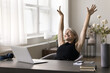 © fizkes - Happy serene mid aged lady office worker stretch hands up enjoy friday end of workday after job is done. Smiling senior woman freelancer relax rest do simple gymnastics at workplace in moment of peace