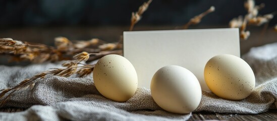 Leinwandbilder - Easter eggs on a linen napkin alongside a blank visit card with copyspace for text
