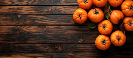Leinwandbilder - Ripe orange persimmons on a brown wooden table Background of persimmons with copyspace for text
