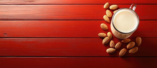 Poster - Freshly squeezed diet beverage Almond milk and nuts on a red wooden surface copyspace Organic plant based milk