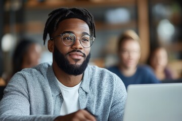 A man thoughtfully engages with his laptop in a trendy cafe, capturing the blend of work and relaxation in a contemporary, casual atmosphere of success.