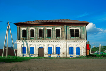 Carved window frames around an old house. View of a fragment of a house wall with carved decorations around the window and doors. Traditional Russian old houses. Close-up. Front view