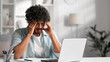 © YURII MASLAK - A young Indian male businessman is sitting at a desk trying to work, checking schedules and getting frustrated that something is not working out. Headache, fatigue, burnout.