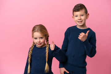 Wall Mural - Little caucasian brothers isolated on pink background with thumbs up because something good has happened