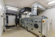 © alhim - A large air handling unit is installed in a commercial utility room, featuring extensive ductwork and control panels, ensuring efficient air circulation and ventilation..