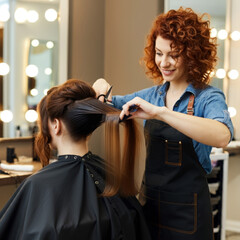 Wall Mural - Beautiful Girl slilled hairdresser doing hair styling to client in beauty salon, cutting the ends of the hair, stylist doing hair care procedures