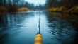 © Galib - A fishing rod resting on the water, with a blurry background.