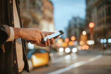 Close-up of male hands with smartphone outdoors