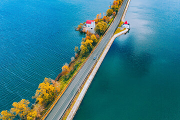 Fototapete - Aerial drone view of asphalt road with cars over blue water lake and autumn color trees
