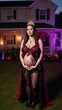 © Pixel Matrix - A pregnant woman is seen in Halloween costume against spooky house backdrop at night under moody lighting