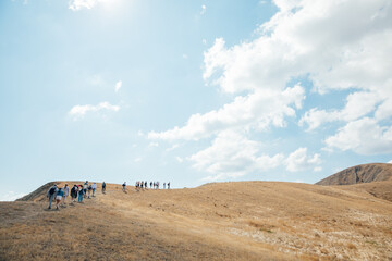 Tourists travelers climb to the top of the mountain on a hike