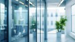 © backup_studio - Blurred office interior background. Empty light open space office with big windows, many glasses walls, desks, chairs and green plants. Modern indoor business environment