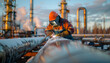© Oleksiy - Welder performing welding work on pipeline against blurred background of factory
