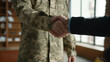 © Yuliia - Unknown Caucasian male officer camouflage uniform guy man military army soldier veteran handshake arms psychologist businessman inside office cabinet psychology support healthcare war hero army forces