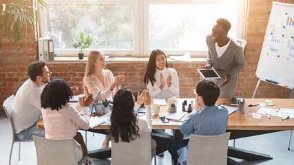 Wall Mural - Black guy with digital tablet making report during business meeting in modern office