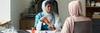 © pressmaster - Muslim physician wearing a stethoscope engaging with patient, explaining prescribed medication while seated in office environment, with medical supplies in background