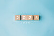 © olyphotostories - 2025 New Year Loading. Loading bar with wooden blocks 2025 on blue background. Start new year 2025 with goal plan, goal concept, action plan, strategy, new year business vision.
