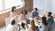 © Prostock-studio - Enthusiastic girl sharing her ideas with cheerful multiracial colleagues while meeting in office, high angle view