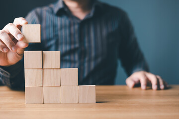 hand of a businessman stacking wood empty ten blocks with copy space for text or symbols, developmen