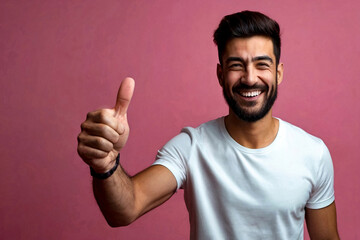 Young man at pink background showing gesture up, very happy and excited, looking at camera. Guy in t-shirt with sign good, smiling and thinking for success. Winning concept. Copy text space