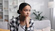 © YURII MASLAK - Attractive African American girl sitting in living room, resting
