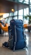 © Sasa Visual - A spacious dark blue backpack with ergonomic straps waits in a comfortable airport lounge setting