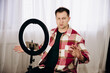 © Alexey - A man in a plaid shirt communicates via video link. Conference of a blogger with a ring lamp