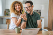 © Miljan Živković - adult couple man and woman shopping online use laptop hold credit card