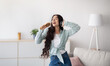 © Prostock-studio - Beautiful Indian lady with headphones dancing and singing, using hairbrush as microphone at home. Millennial woman moving to her favorite song, enjoying music, pretending to be popular star