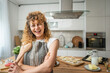 © Miljan Živković - One happy young adult caucasian woman wear apron in the kitchen smile