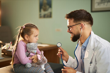 Cute girl talking to her pediatrician at doctor's office. 