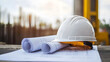 © The Origin 33 - hard hat rests on blueprints at construction site, symbolizing safety and planning